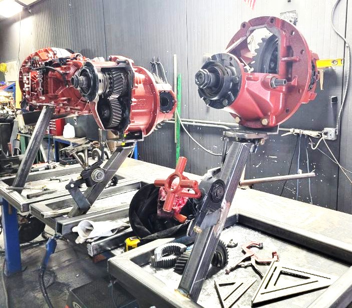 Heavy steel rotating fixtures holding truck differentials during teardown and rebuild