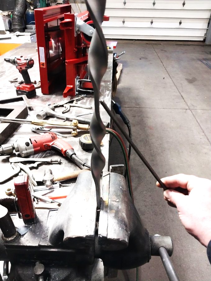 Hand-twisted steel bar formed in the vise for a decorative metalwork project
