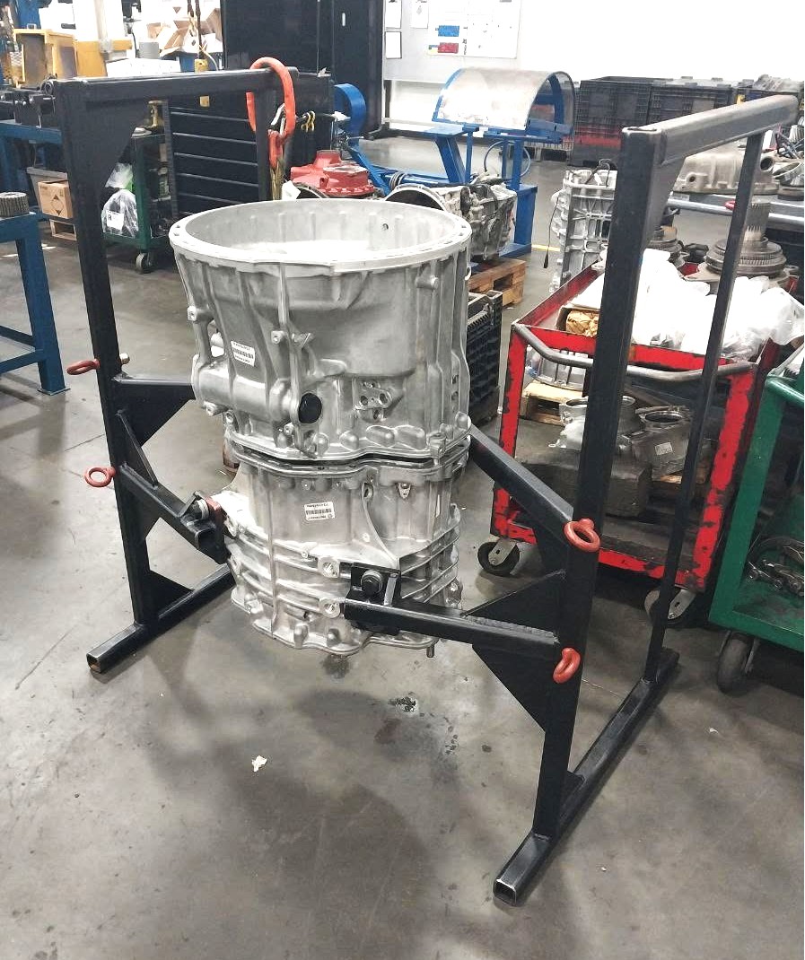 Heavy-duty black steel transmission rotating stand holding an aluminum gearbox housing