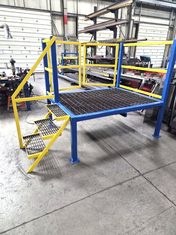 Custom fabricated steel work platform with safety railing and access stairs
