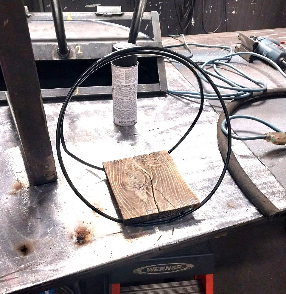 Formed steel ring welded to a torched wood base for a custom decorative piece