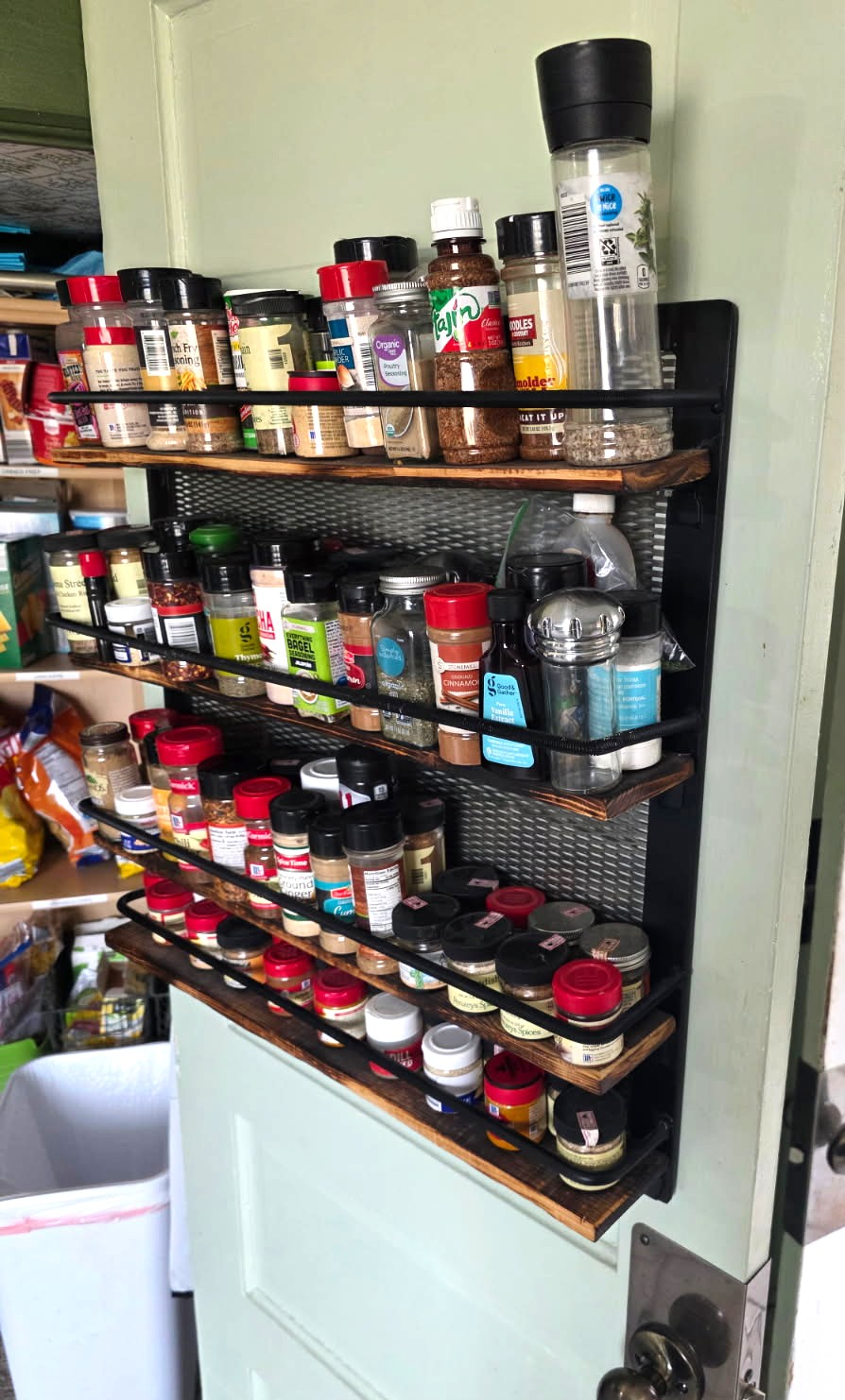 Side view of the fabricated steel-frame spice rack with torched wood shelves and expanded metal back