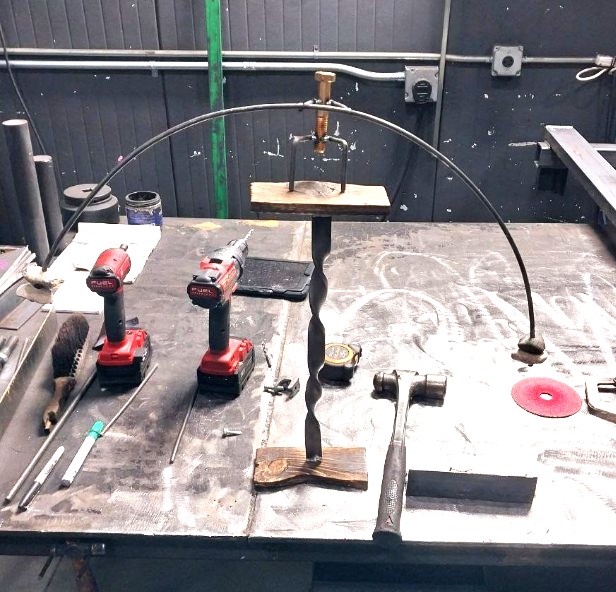 Twisted steel shepherd hook stand assembled on the fabrication table