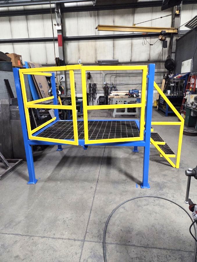 Painted steel elevated work platform with swing gate railing and grated step access