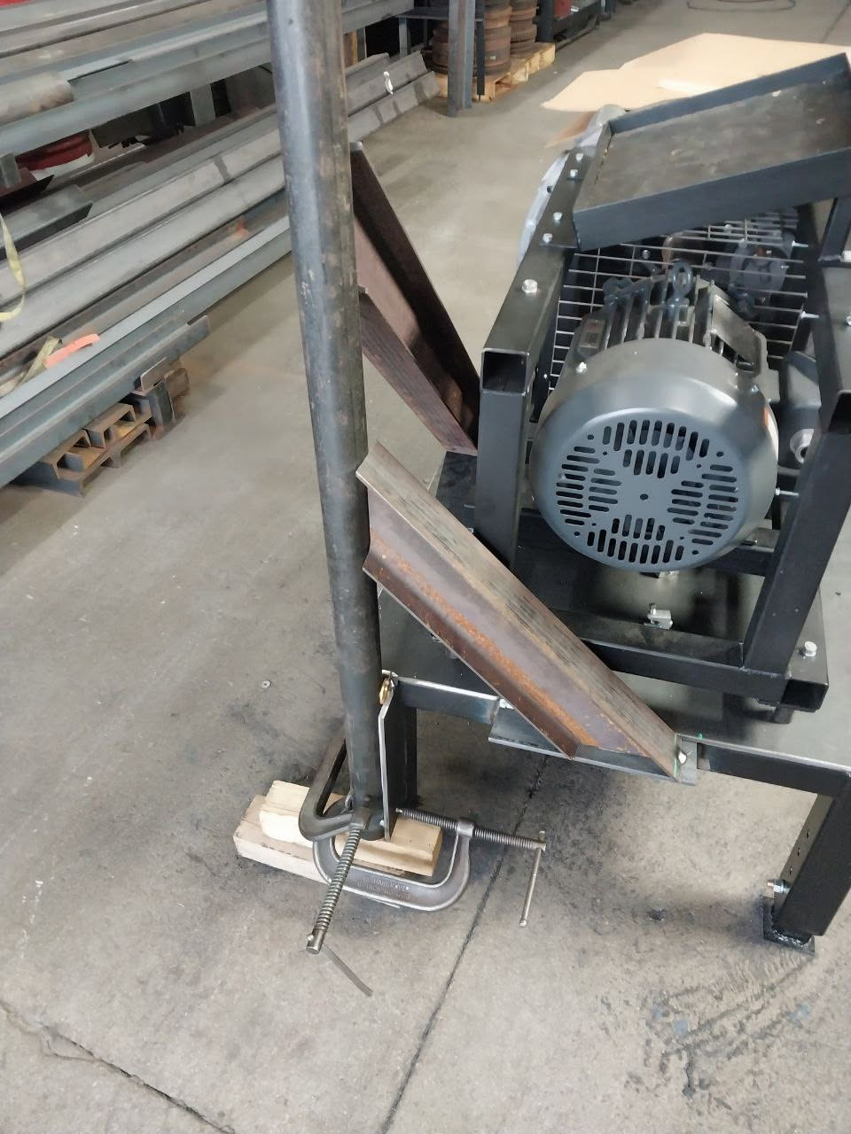 Angled steel supports fit up and clamped alongside shop equipment during fabrication