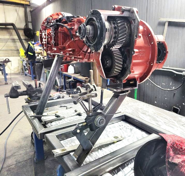 Rebuilt truck differential mounted on a custom-built rotating steel repair fixture