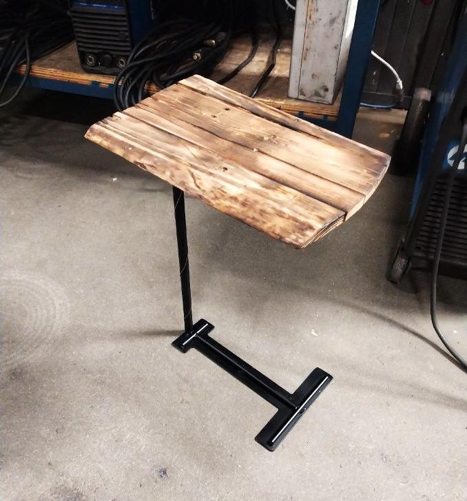 Custom side table built from black steel tubing and reclaimed torched wood