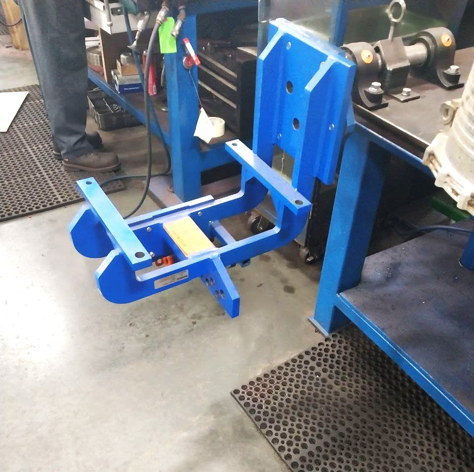 Custom blue powder-coated transmission mounting fixture built for a shop repair stand