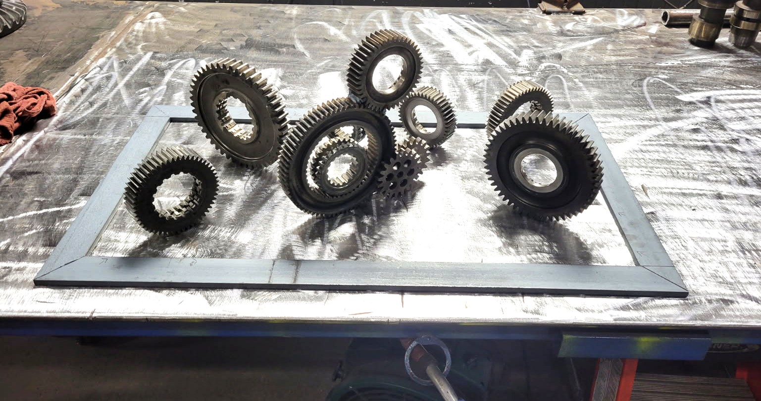 Interlocking steel gears arranged in a welded frame for a custom metal wall art project