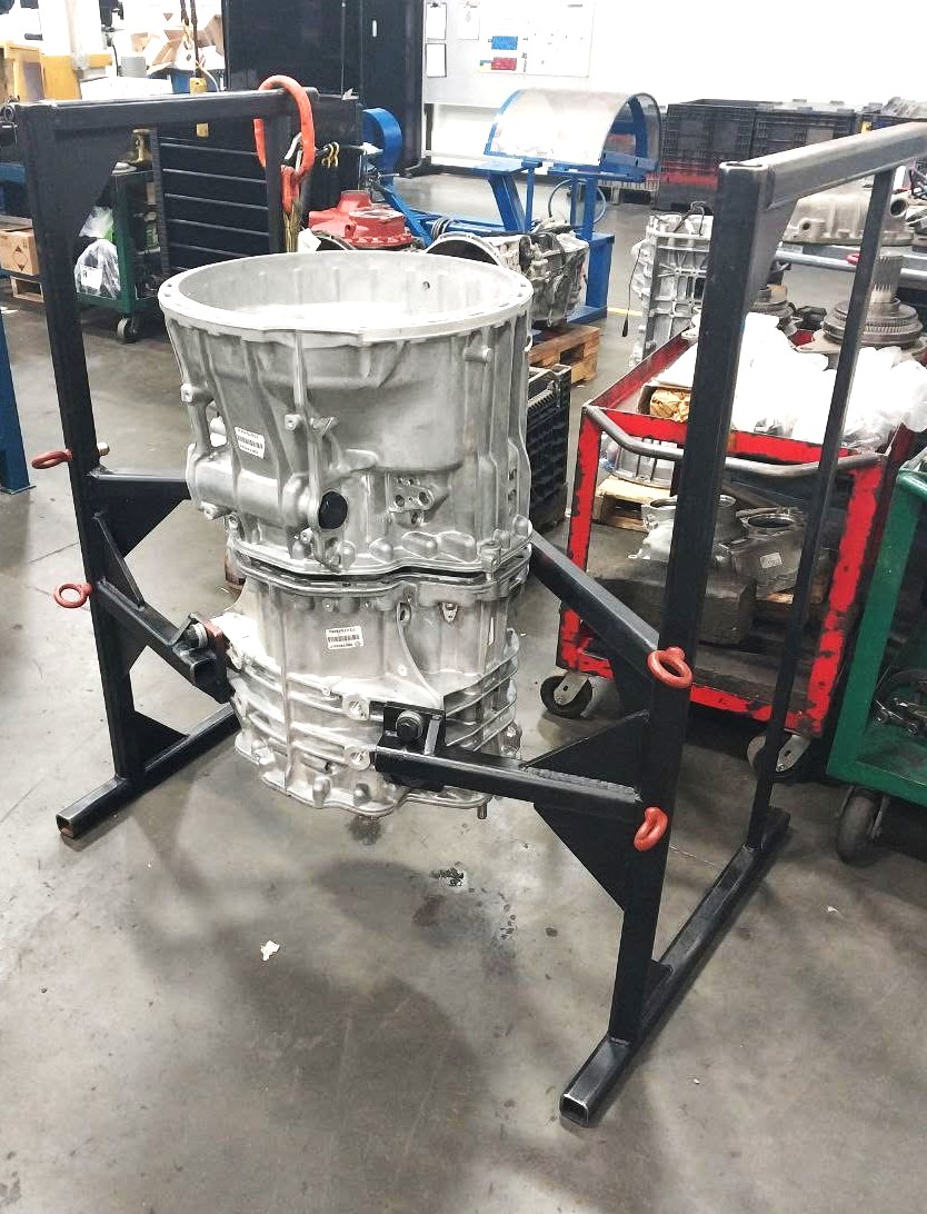 Heavy-duty black steel transmission holding stand with lifting rings and adjustable arms
